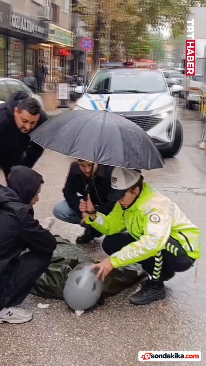 Bursa’da trafik polisi yaralı genci yağmurdan şemsiyeyle korudu